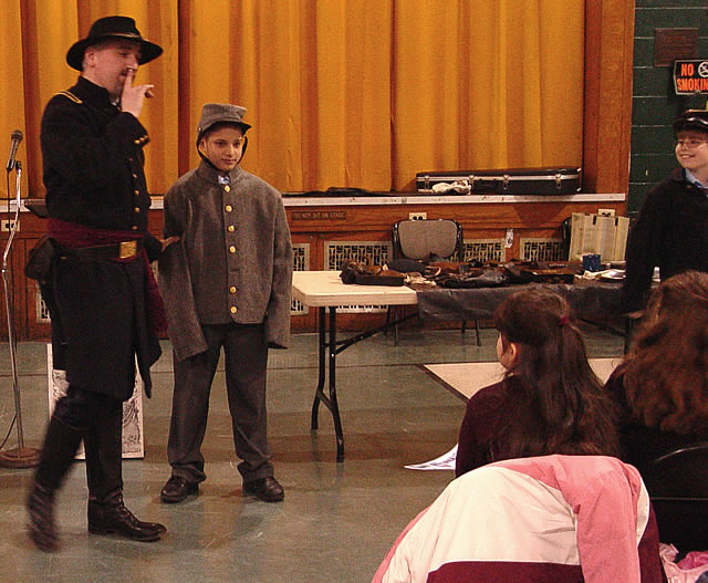 A confederate soldier was found in the class.  How can we tell?  He is wearing a gray uniform.